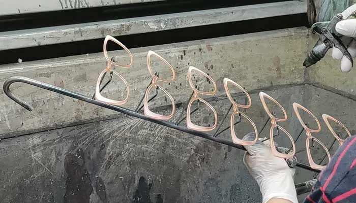 Worker-spraying-color-on-eyeglass-front.jpg worker is spraying color for eyewear frame